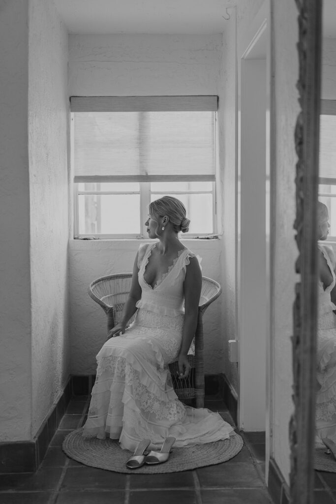 Bride in her wedding dress sitting in chair