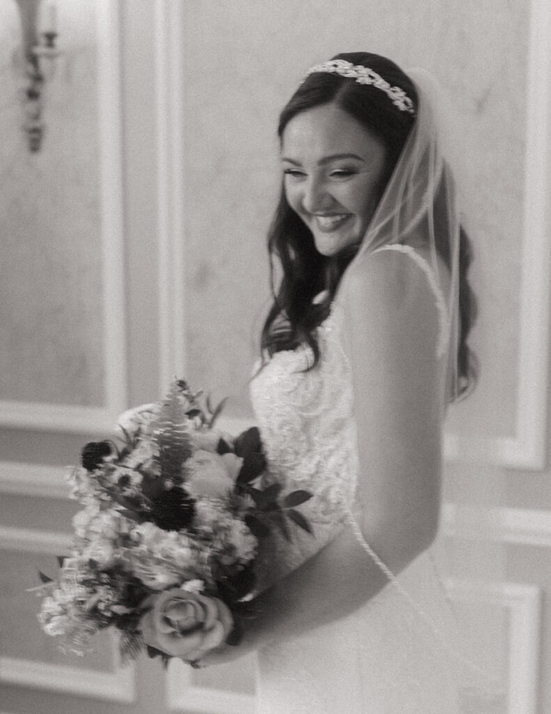 Bride smiling in her wedding dress on her wedding day.