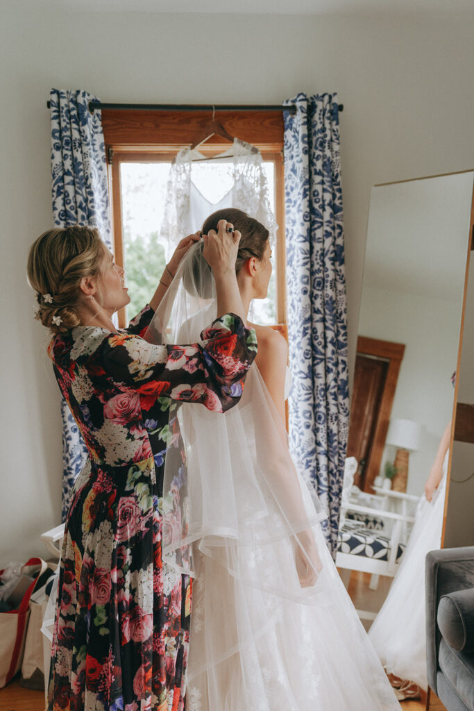 Bride's mom placing veil in bride's hair.
