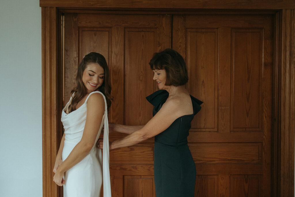 Bride and mom getting dressed on her wedding day.