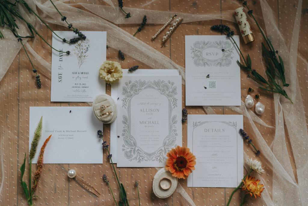 Flatlay of wedding invitations and rings.