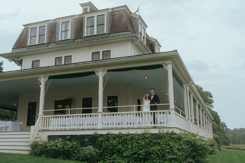 Bride and groom on porch of Grand Isle Lake House 