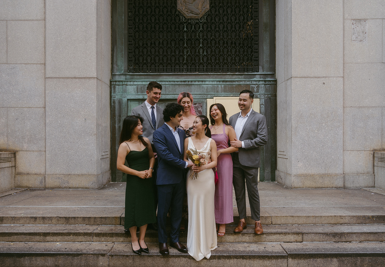 Elopement guests posing with the bride and groom on stone city steps in New York
