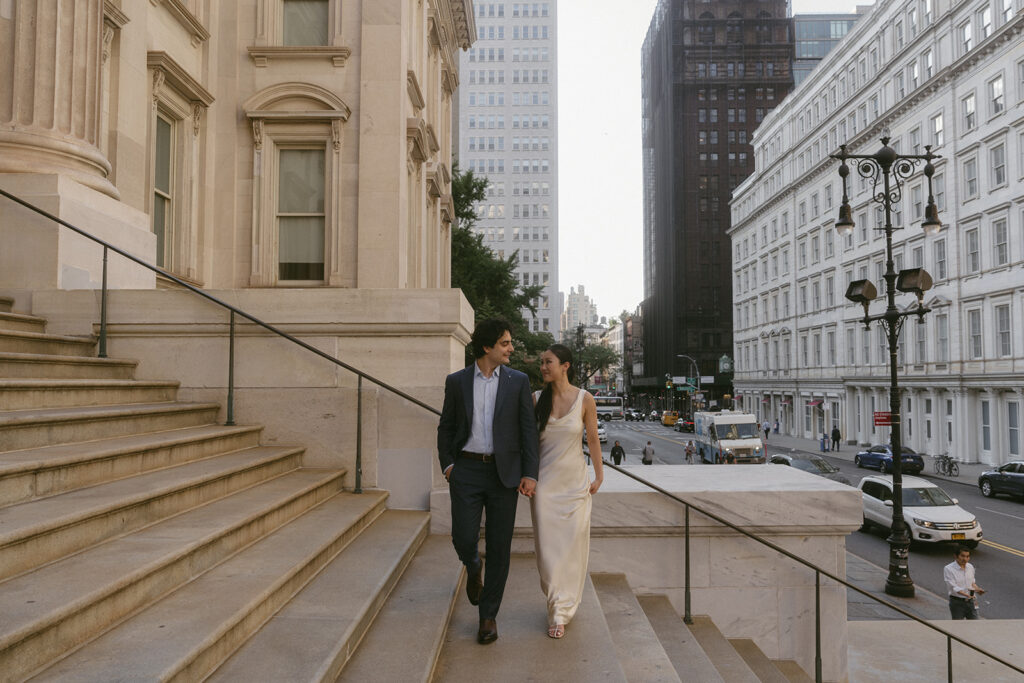 Couple walking in the steps of City Hall in New York City.