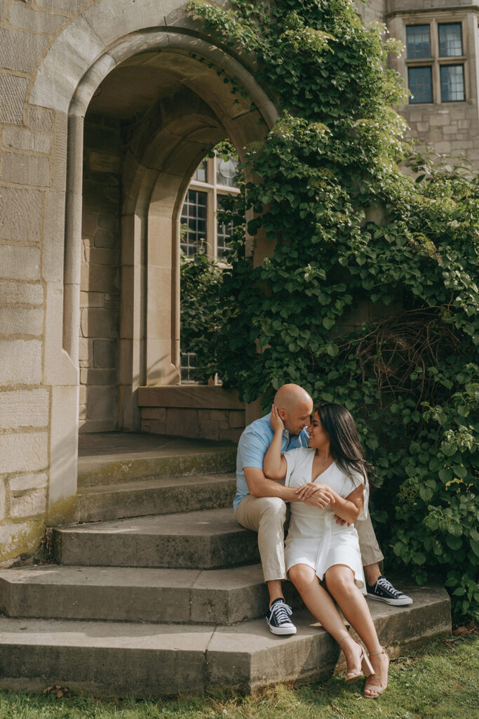Couple kissing on steps of estate.