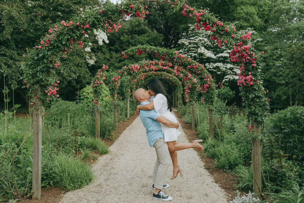 Couple kissing in a floral garden.