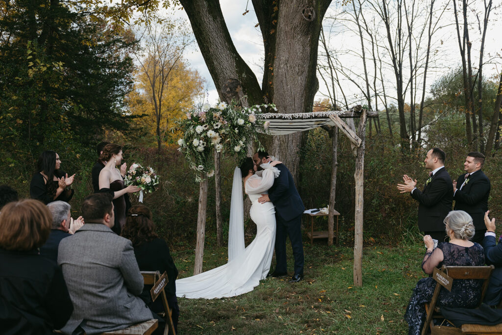 Bride and groom kissing at their Blooming Hill Farm wedding outdoor ceremony