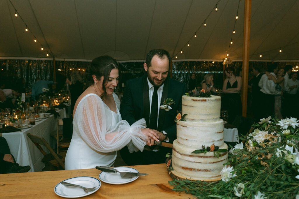 Bride and groom cutting the cake at their Blooming Hill Farm wedding reception