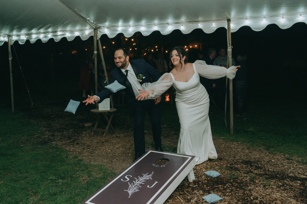 Bride and groom playing corn pole at their wedding reception 