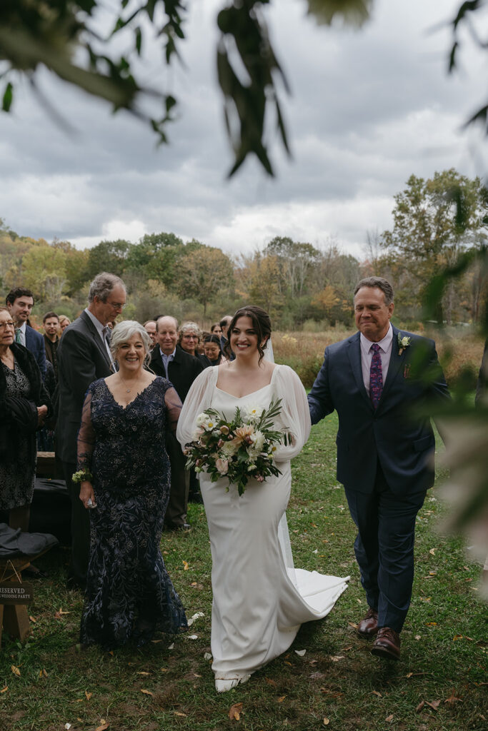 Bride walking down the aisle at her Blooming Hill Farm wedding outdoor ceremony