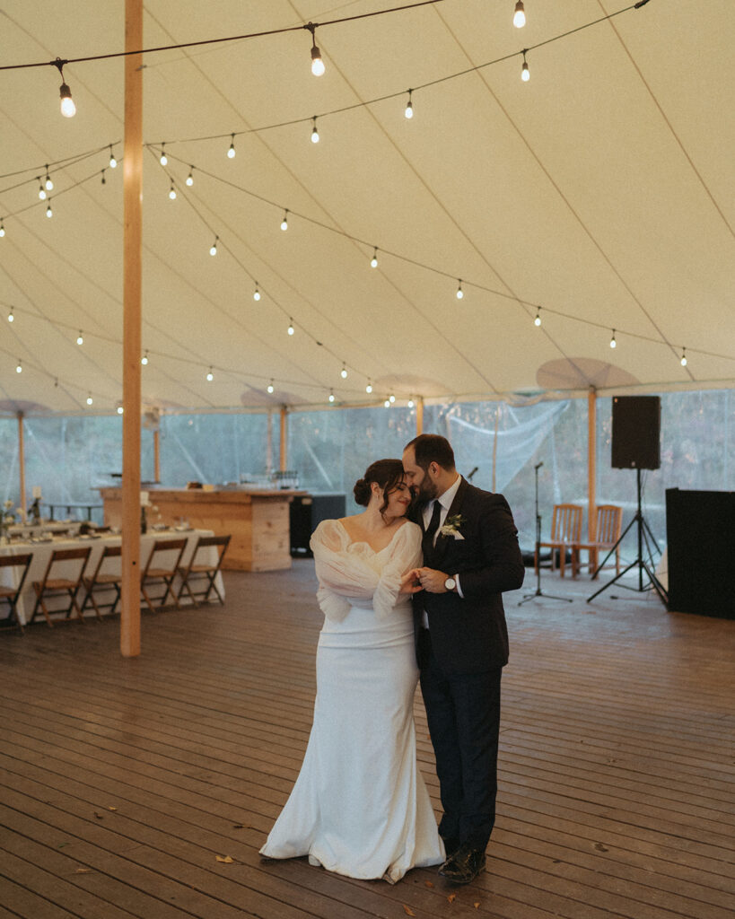 Bride and groom dancing in a tent at their wedding