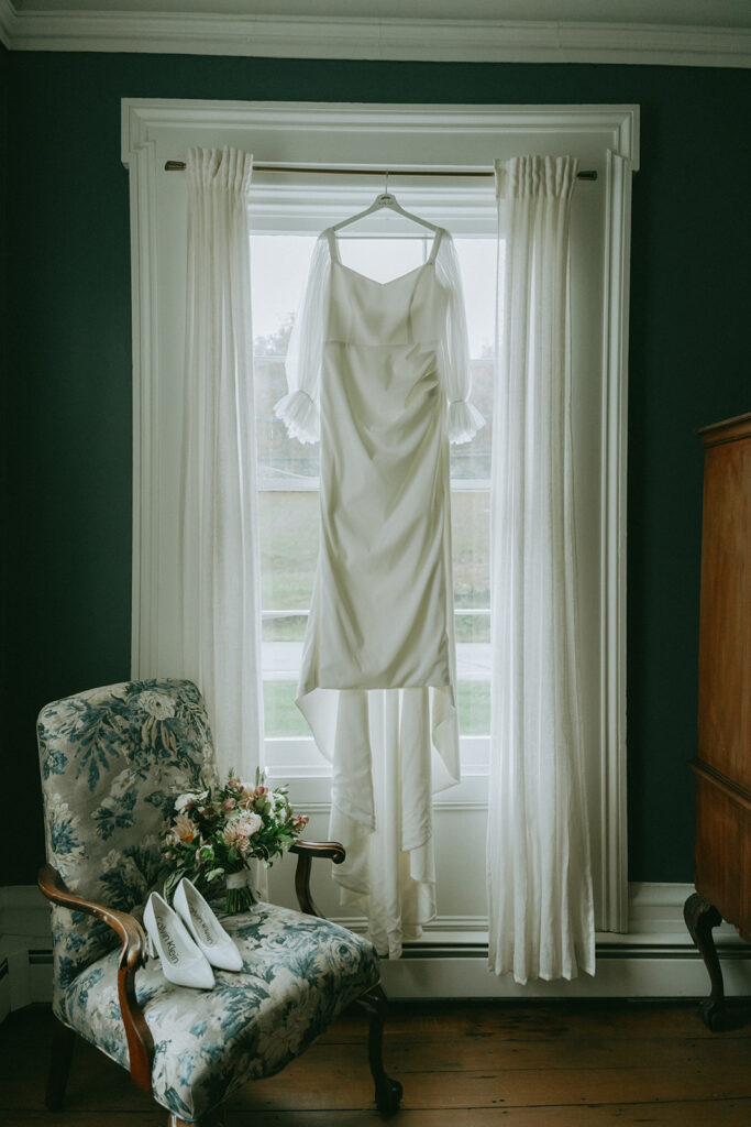 Bridal gown hanging in the window, getting ready at the Peach Grove House for a Blooming Hill Farm wedding.