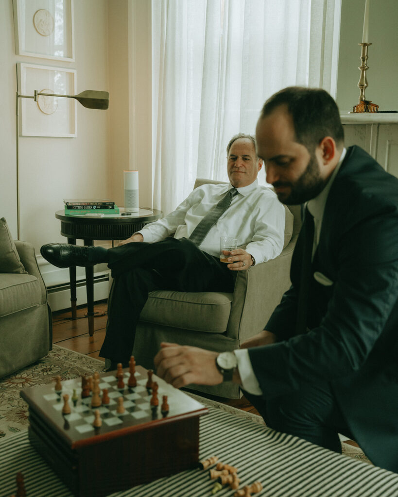 Groom playing chess at the Peach Grove House for a Blooming Hill Farm wedding.