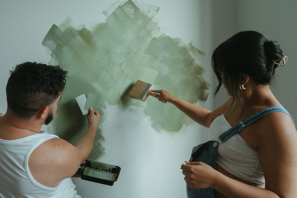 A husband and pregnant wife paint the nursery for their baby-to-be.