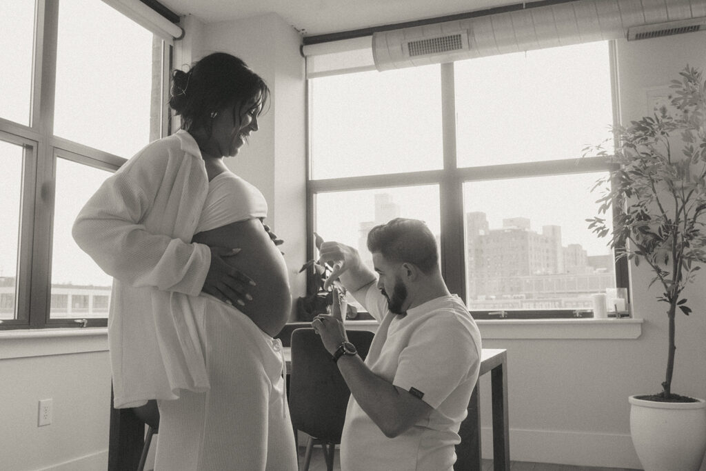 A husband and pregnant wife dancing around their NYC apartment living room.