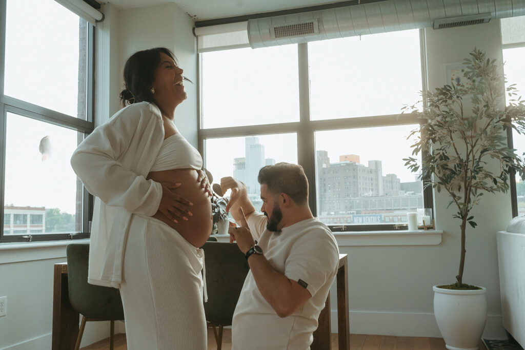 A husband and pregnant wife dancing around their NYC apartment living room.