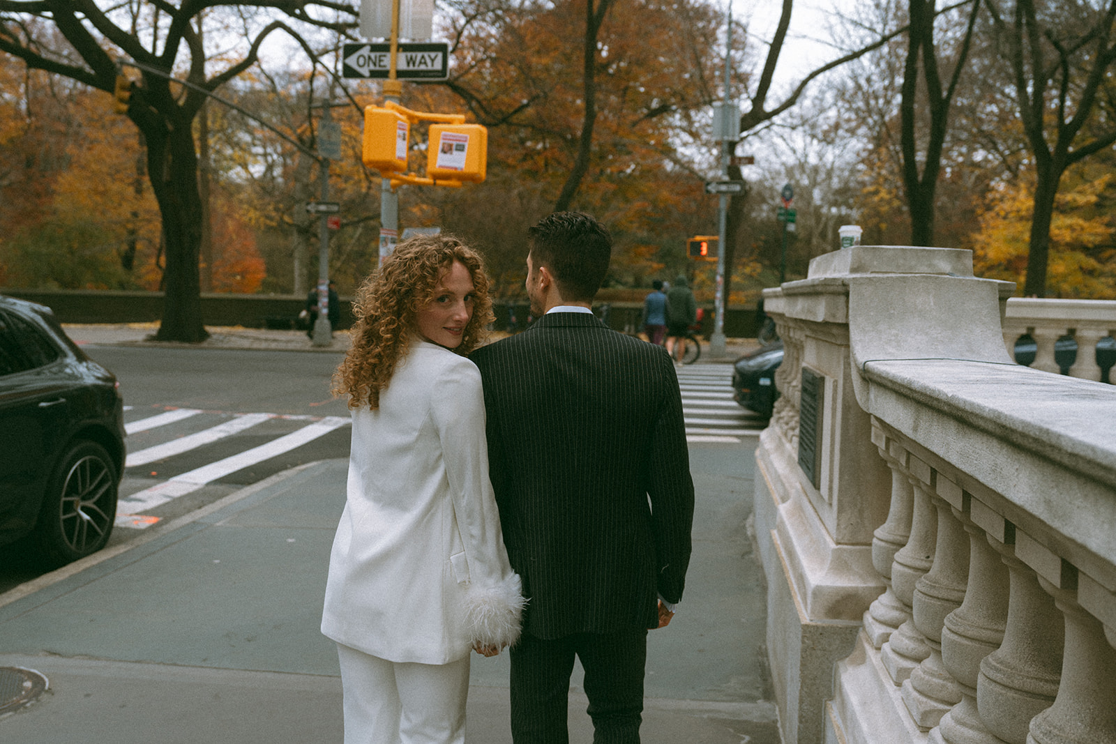 Bride and groom crossing a city street in autumn on their New York elopement day