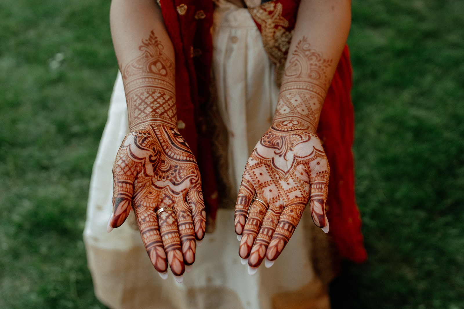 Bride showing intricate mehndi designs on her palms at Catholic Indian wedding event — Elsie Goodman Photography.