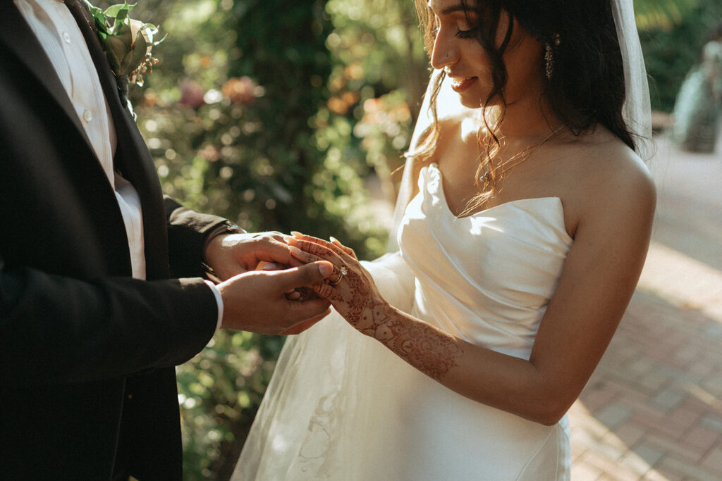 The groom gently holds the bride’s hand while she shows her engagement ring at their Indian Catholic wedding, with the bride wearing a classic Indian Catholic wedding dress, captured by Elsie Goodman Photography.