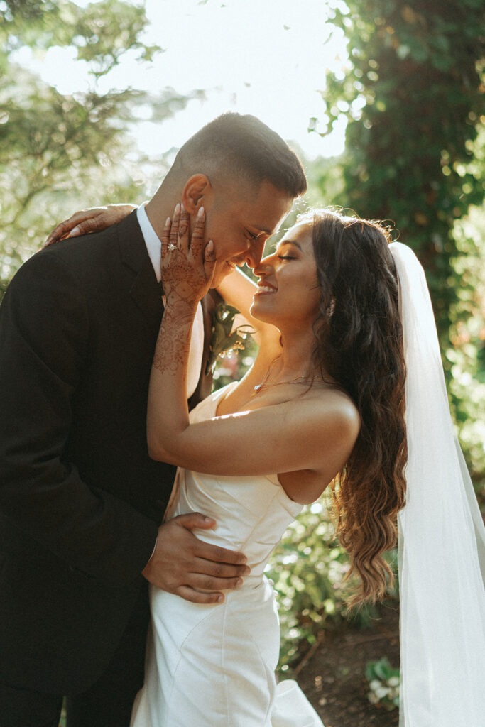 The bride and groom laugh in the sunlight during their Long Island wedding celebration at Crest Hollow Country Club, captured by Elsie Goodman Photography for their Indian wedding photo gallery.