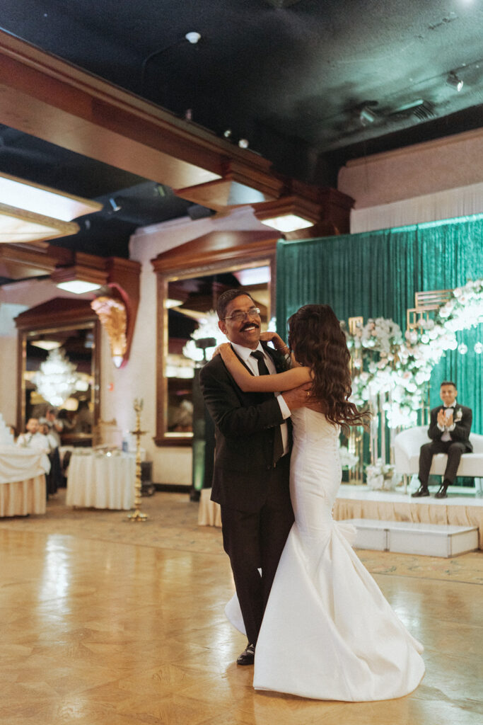 The bride dances joyfully with her father during an emotional father-daughter dance at a Catholic Indian wedding reception at Crest Hollow Country Club, photographed by Elsie Goodman Photography as part of an elegant Indian wedding photo gallery.