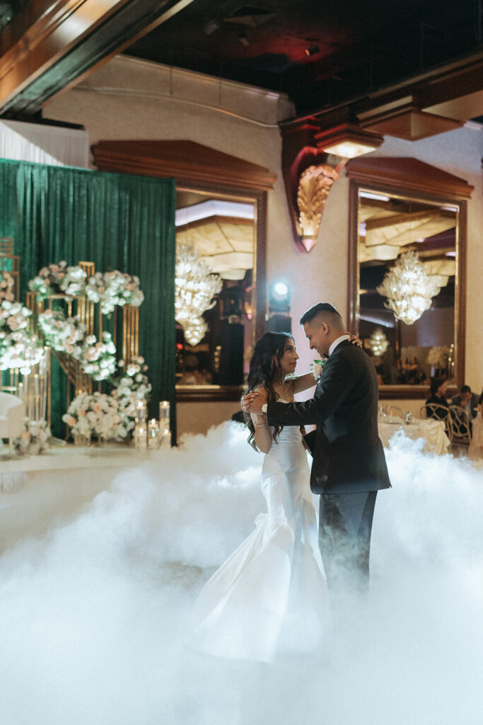 Newlyweds share a first dance on a cloud-covered dance floor at their Catholic Indian wedding at Crest Hollow Country Club, with every magical detail captured by Elsie Goodman Photography for a breathtaking Indian wedding photo gallery.