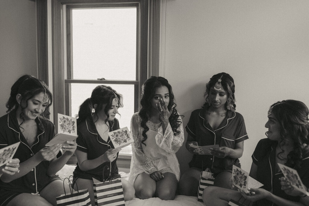 Bride getting emotional while exchanging cards with bridesmaids before Catholic Indian wedding ceremony — Elsie Goodman Photography.