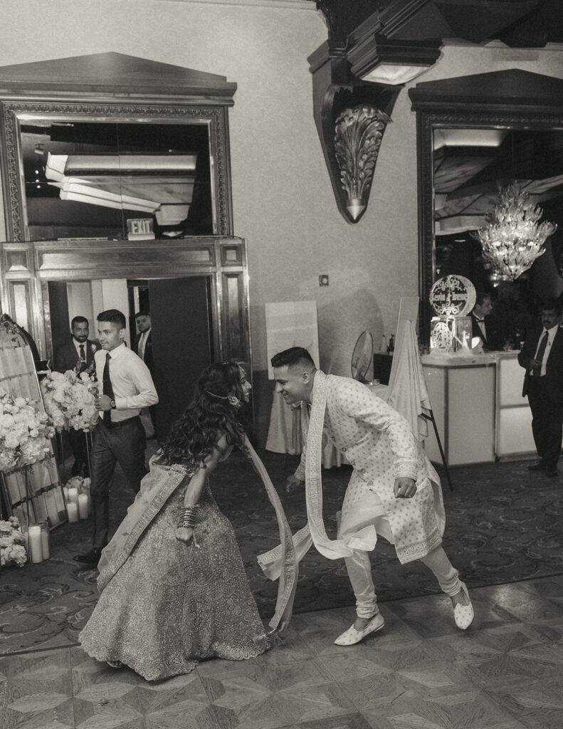 Bride and groom laughing and dancing together at their Indian Catholic wedding reception at Crest Hollow Country Club, captured by Elsie Goodman Photography.