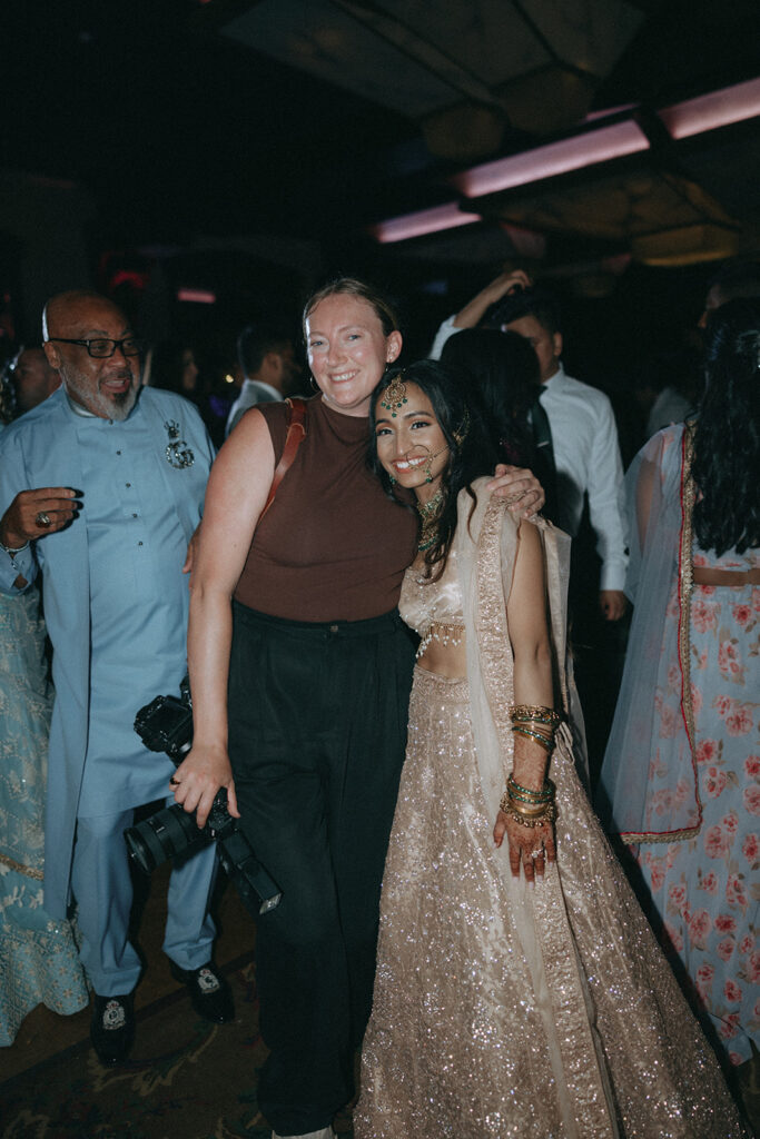 Bride in a sparkling Indian catholic wedding dress posing with her wedding photographer Elsie Goodman at a joyful Crest Hollow Country Club wedding celebration, at one of the most festive Indian wedding venues on Long Island.