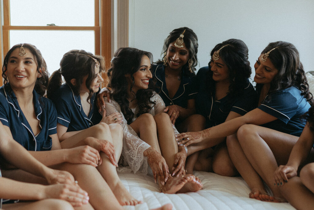 Bride with bridesmaids in matching bridesmaid pjs before Catholic Indian wedding ceremony — Elsie Goodman Photography.