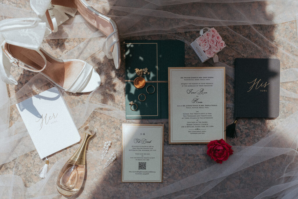 Flat lay of bride’s wedding accessories with vow books, high heels, rings, and floral decor for Catholic Indian wedding, captured by Elsie Goodman Photography.