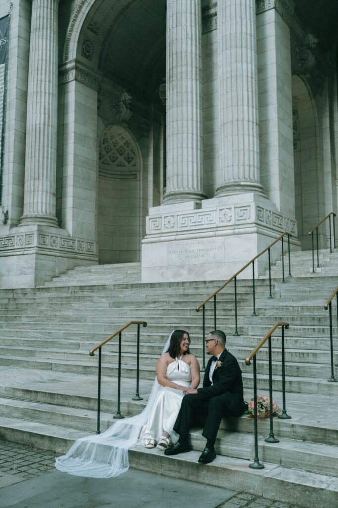 Bride and groom share a quiet moment on the NYPL steps during their elopement, by Elsie Goodman.