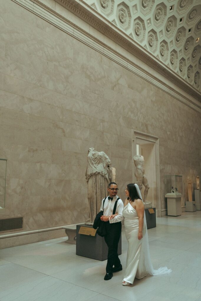 Bride and groom walk through the MET after their library wedding, by Elsie Goodman.