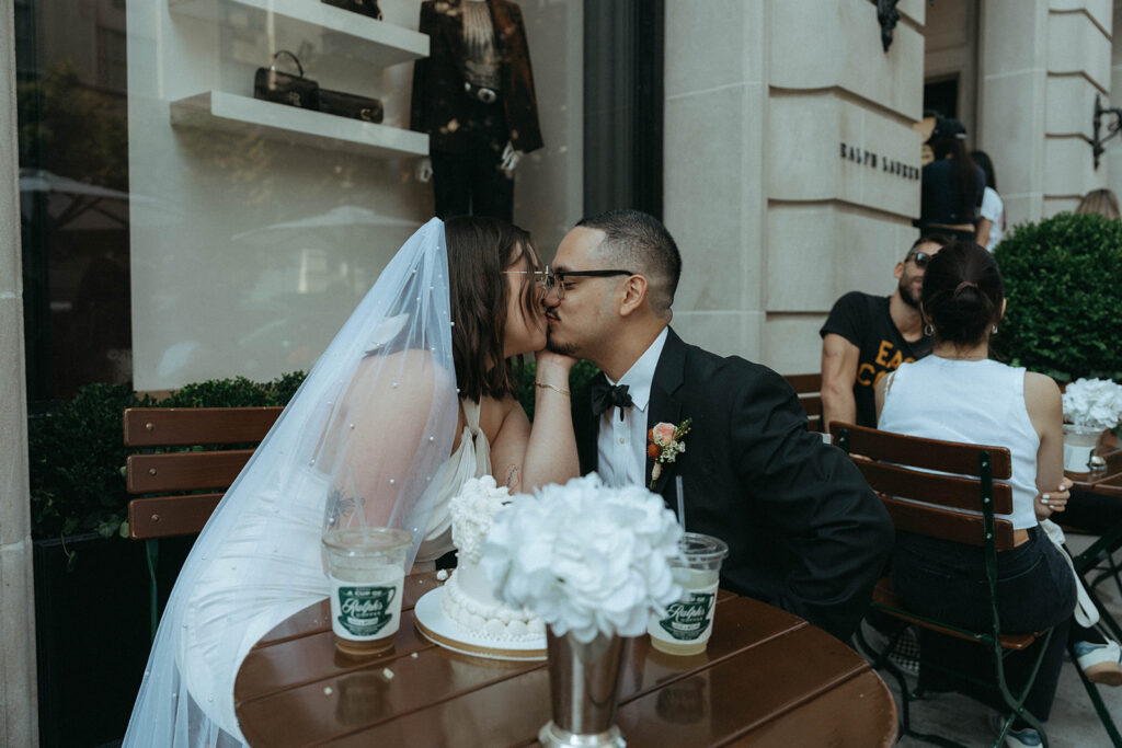 Bride and groom kissing at Ralph's NYC after eloping, by Elsie Goodman Photography.