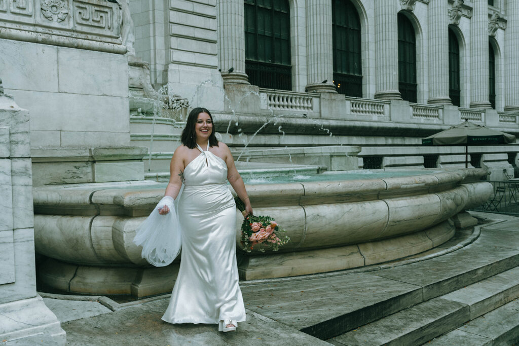 Candid of bride at the NYPL fountain after eloping, shot by Elsie Goodman Photography.