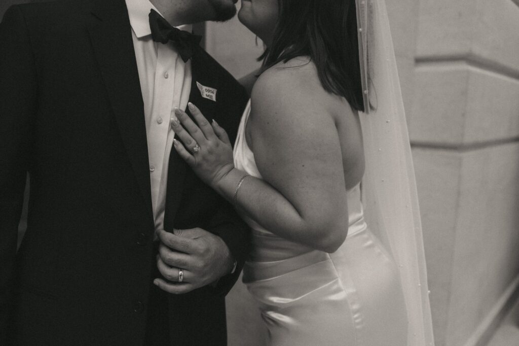 Black-and-white close-up photo of bride kissing groom at NYPL elopement, photo by Elsie Goodman.