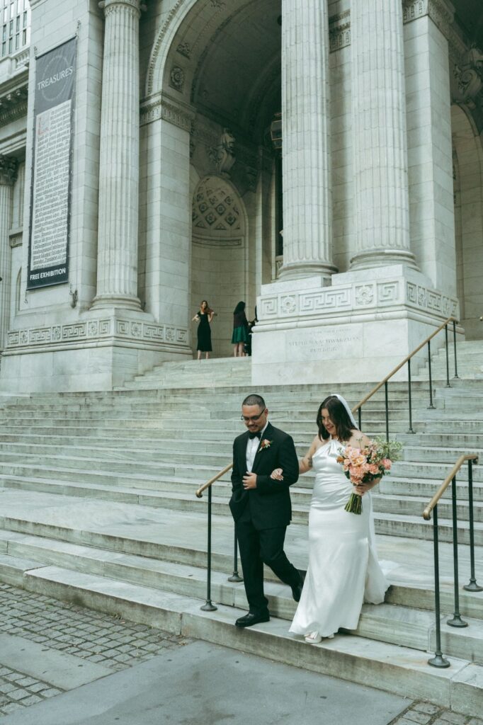 Bride and groom descend NYPL steps as violinist plays by library entrance, captured by Elsie Goodman.