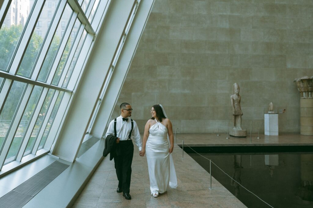 Couple walks hand in hand at the MET after their NYPL elopement, by Elsie Goodman