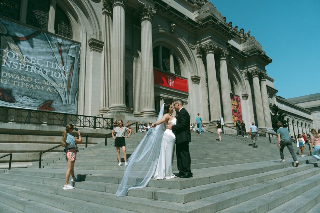 Bride and groompost on the MET steps after their NYPL elopement, by Elsie Goodman