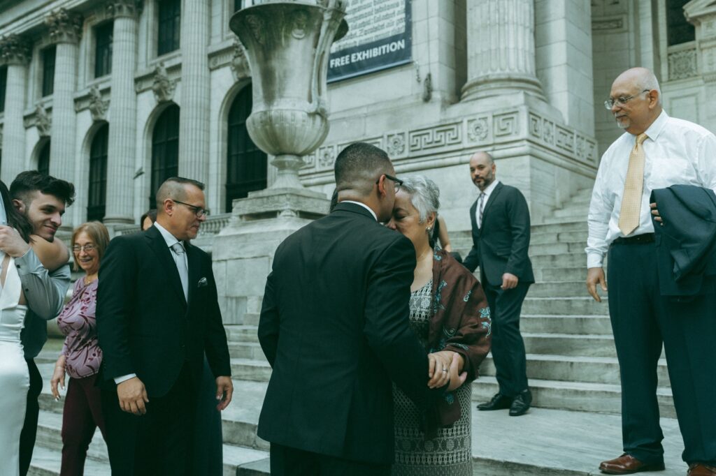 Groom kisses his mom's forehead after NYPL wedding ceremony, shot by Elsie Goodman.