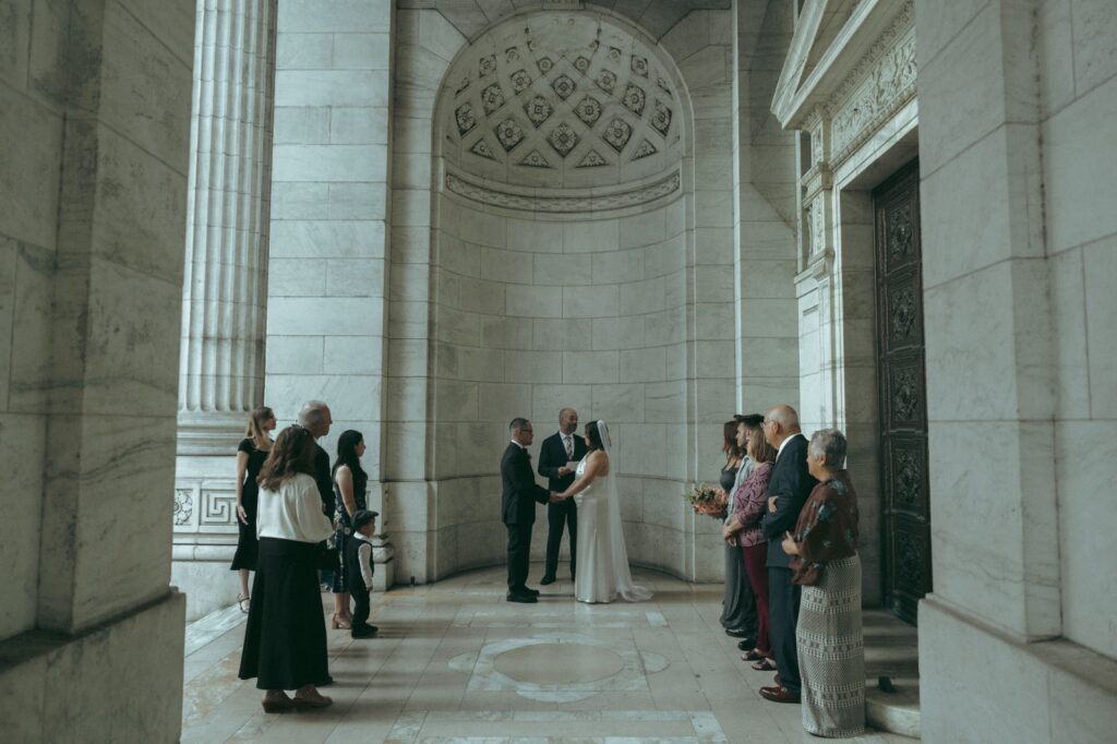 Bride and groom eloping at the NYPL with a small group of guests, shot by Elsie Goodman.