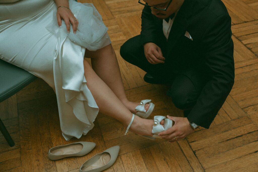 Groom helps bride change shoes after eloping, shot by Elise Goodman Photography.
