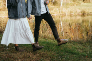 Couple walking hand in hand with wine, wearing blundstones, by Elsie Goodman Photography.