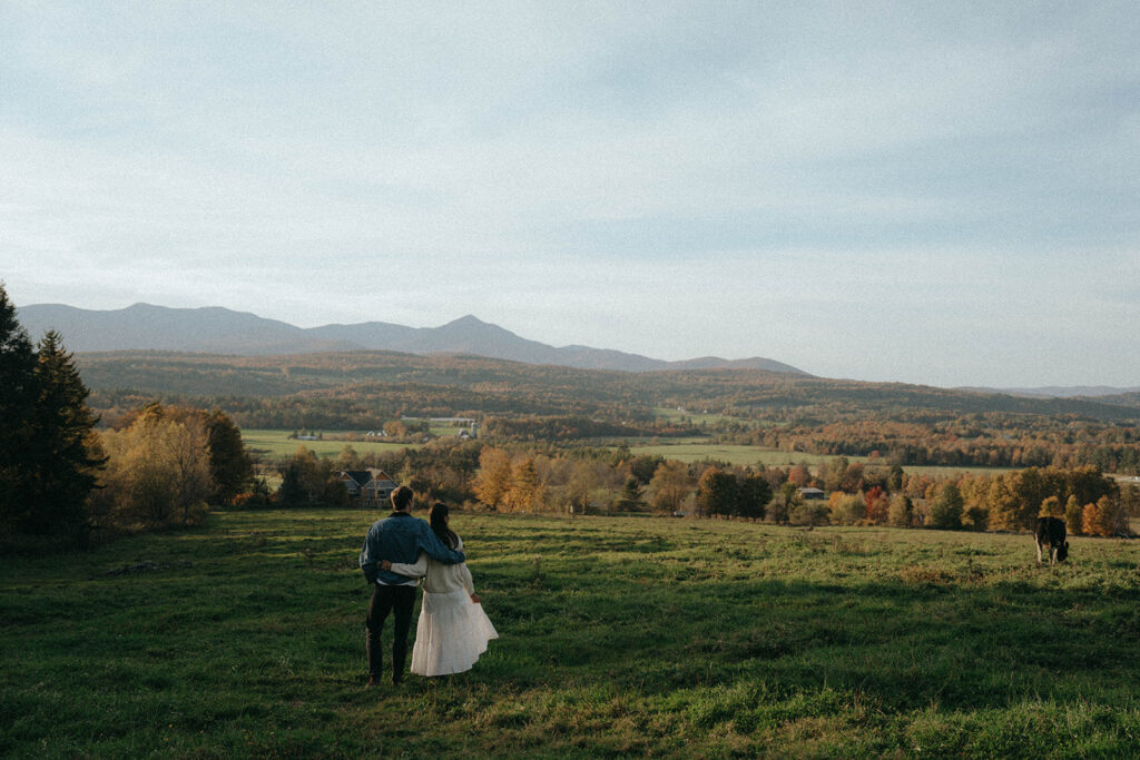 Couple looks out at rolling hills and foliage during their Vermont engagement, captured by Elsie Goodman.
