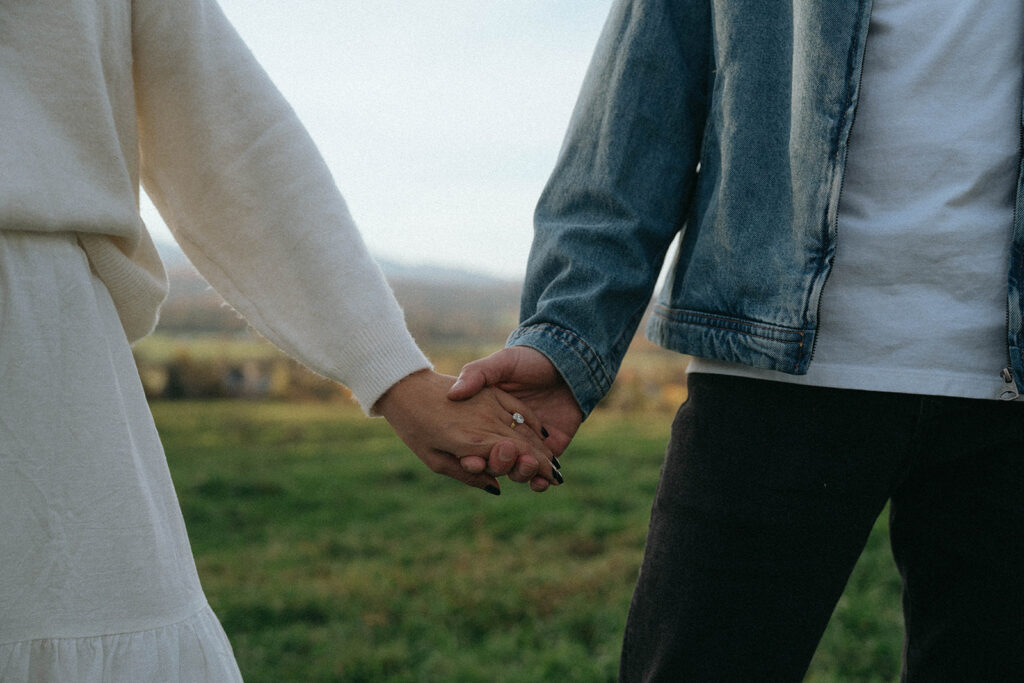 Close-up of couple holding hands, showing her ring during Vermont engagement photos by Elsie Goodman.
