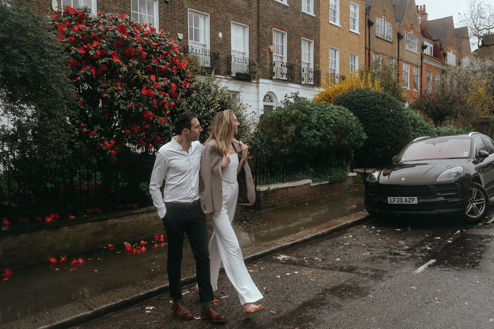 Man and woman look away from the camera, up a london street as they cross it, arm in arm, shot by London engagement photographer Elsie Goodman.