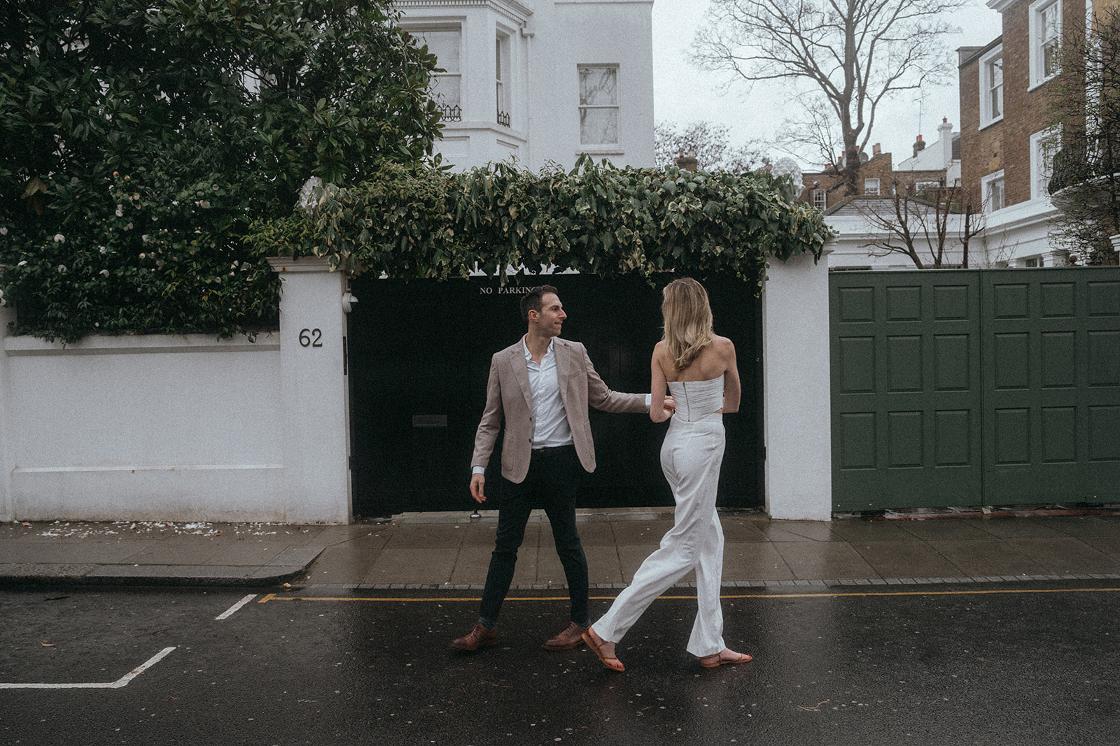 Man and woman in a rainy London street, shot by London engagement photographer Elsie Goodman.
