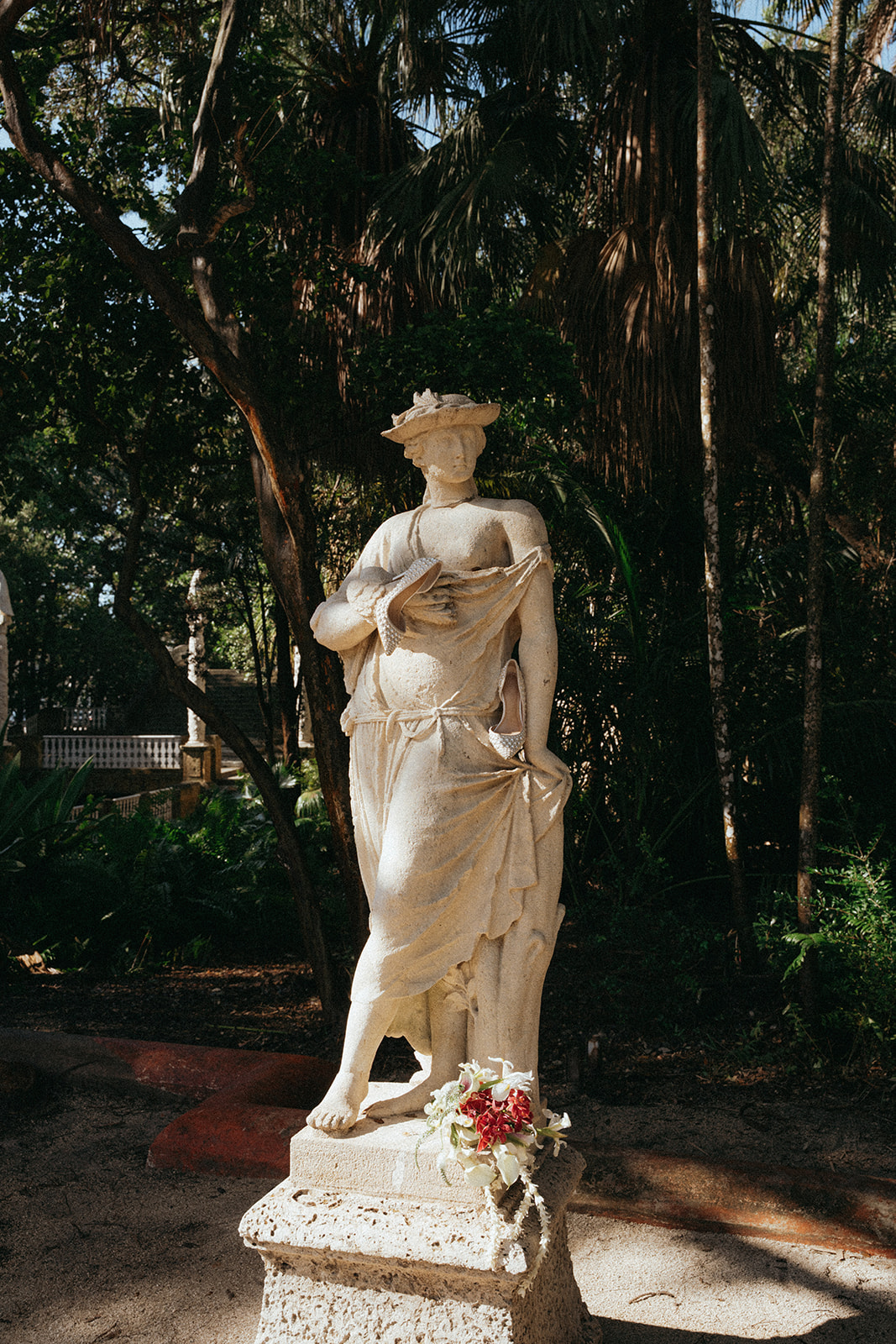 Viscaya Photo of a concrete garden statue with the bridal bouquet at the base by Vizcaya Wedding Photographer Elsie Goodman.