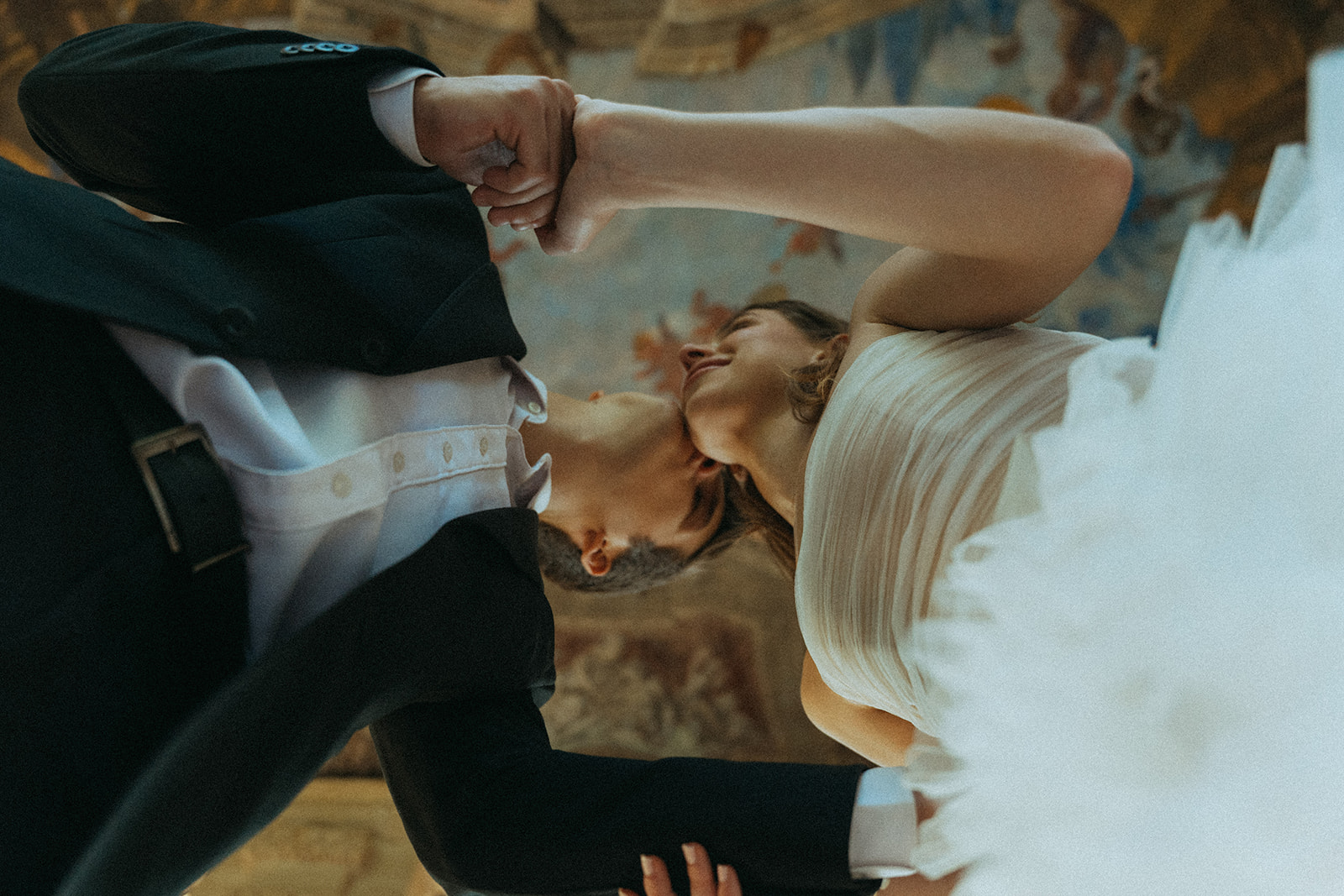 Viscaya Shot of the bride and groom from below as they kiss and hold hands, this angle shows off the painted ornate ceiling by Vizcaya Wedding Photographer Elsie Goodman.