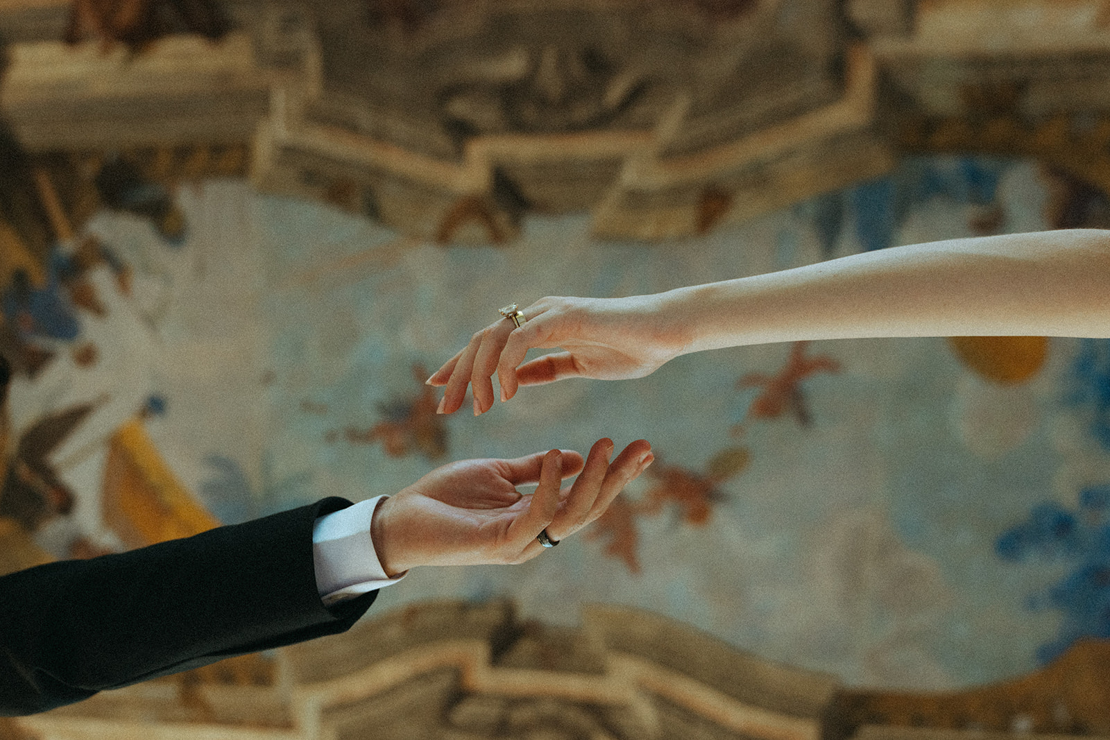 Viscaya Underneath shot of the bride and grooms hands outstretched almost grasping each other, this angle shows off the ornate painted ceiling by Vizcaya Wedding Photographer Elsie Goodman.